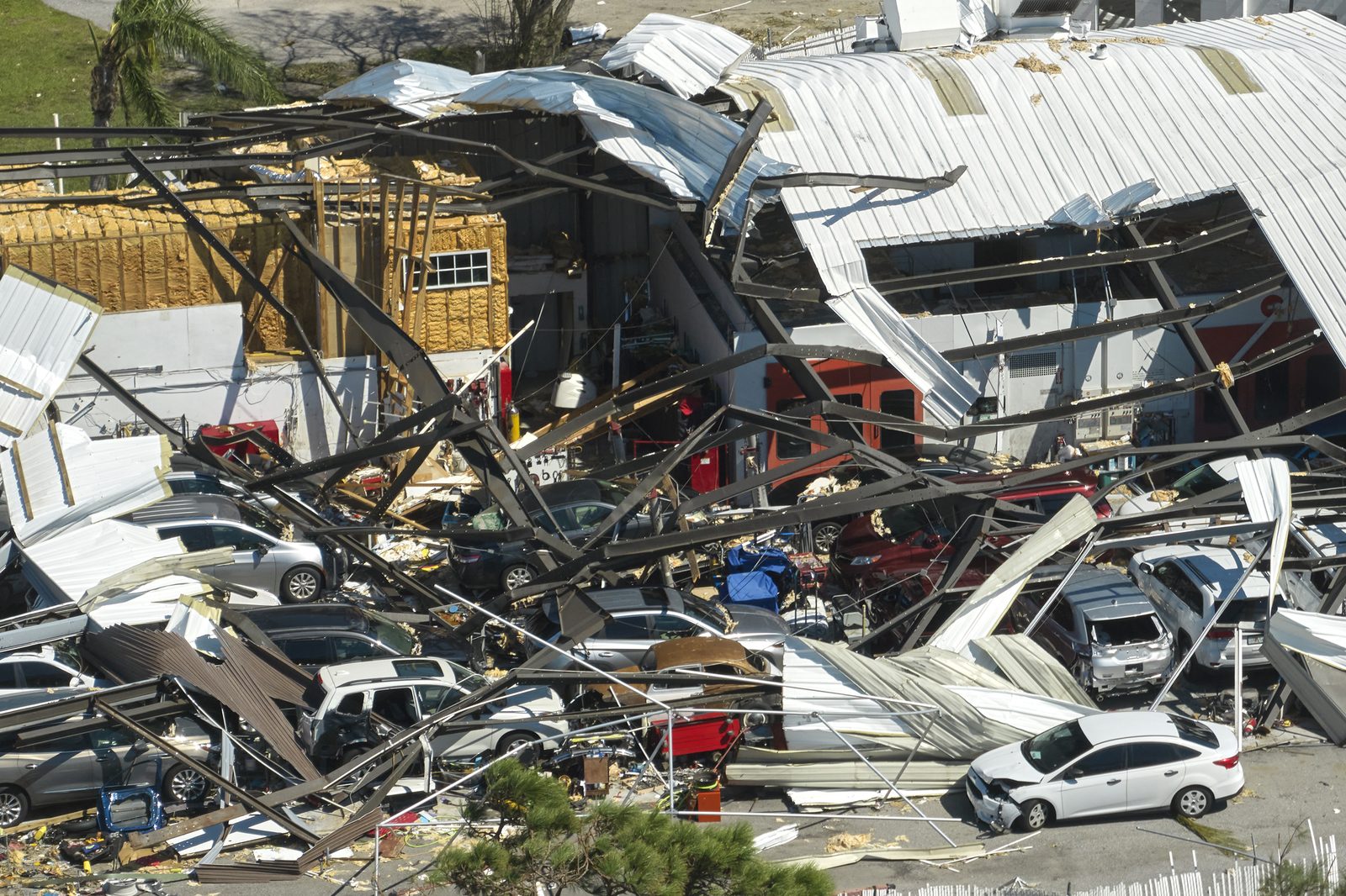 Dealership building collapsed onto rows of cars after a storm