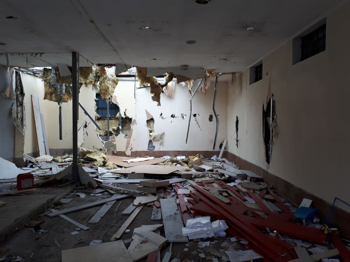 Collapsed ceiling and structural debris inside a damaged commercial interior