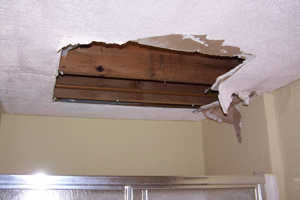 Storm-damaged roof decking exposing interior framing at a church or school building