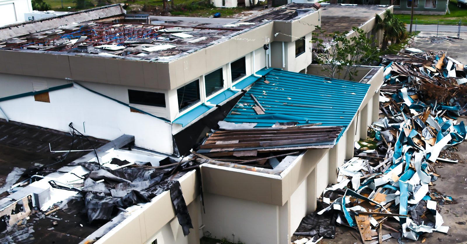 Hurricane-damaged roofs on a block of condominium buildings covered with blue tarps