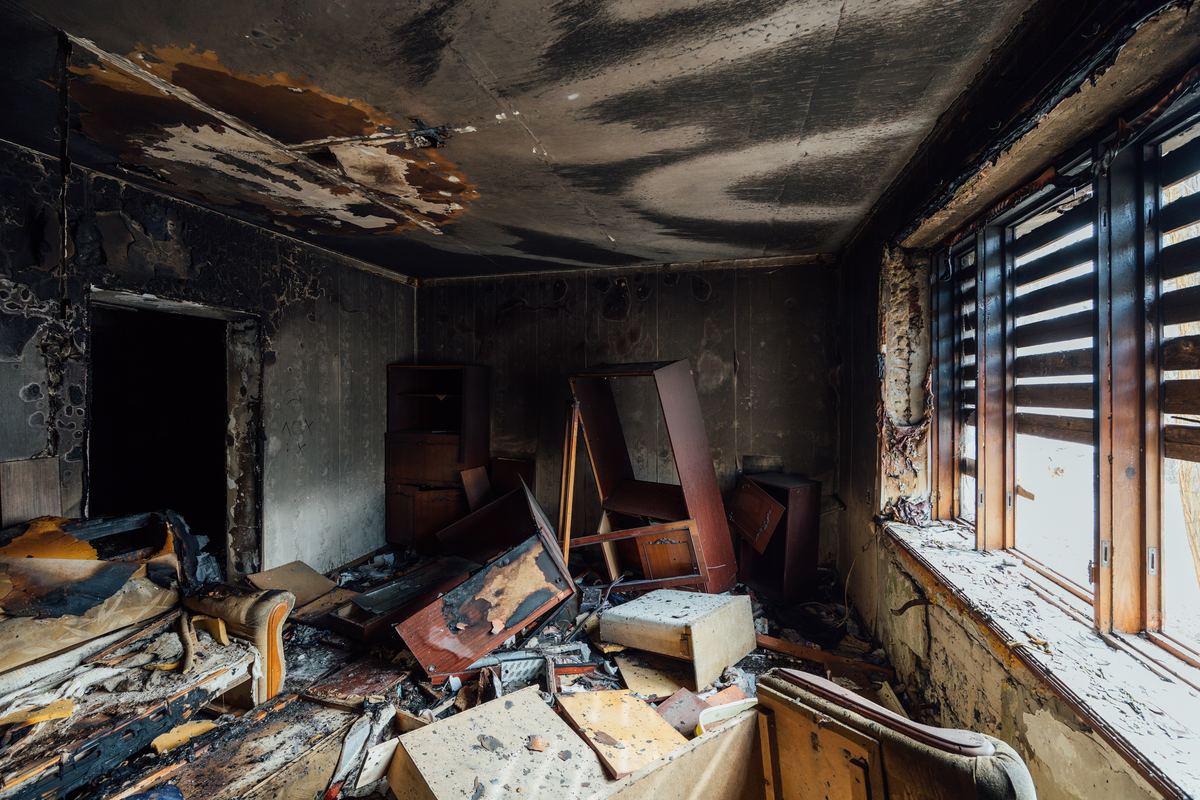 Fire-damaged furniture and contents inside a condo unit after a building fire