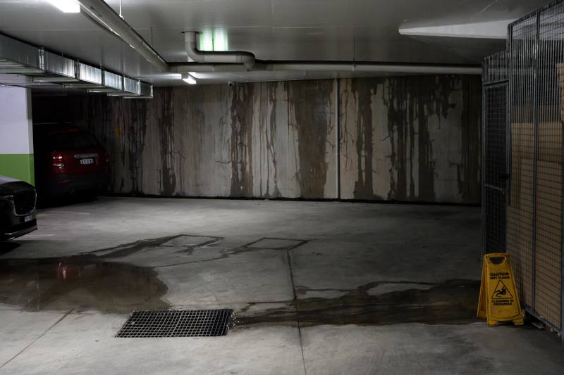 Water staining on the walls of a flooded underground parking garage at a condo or HOA association building