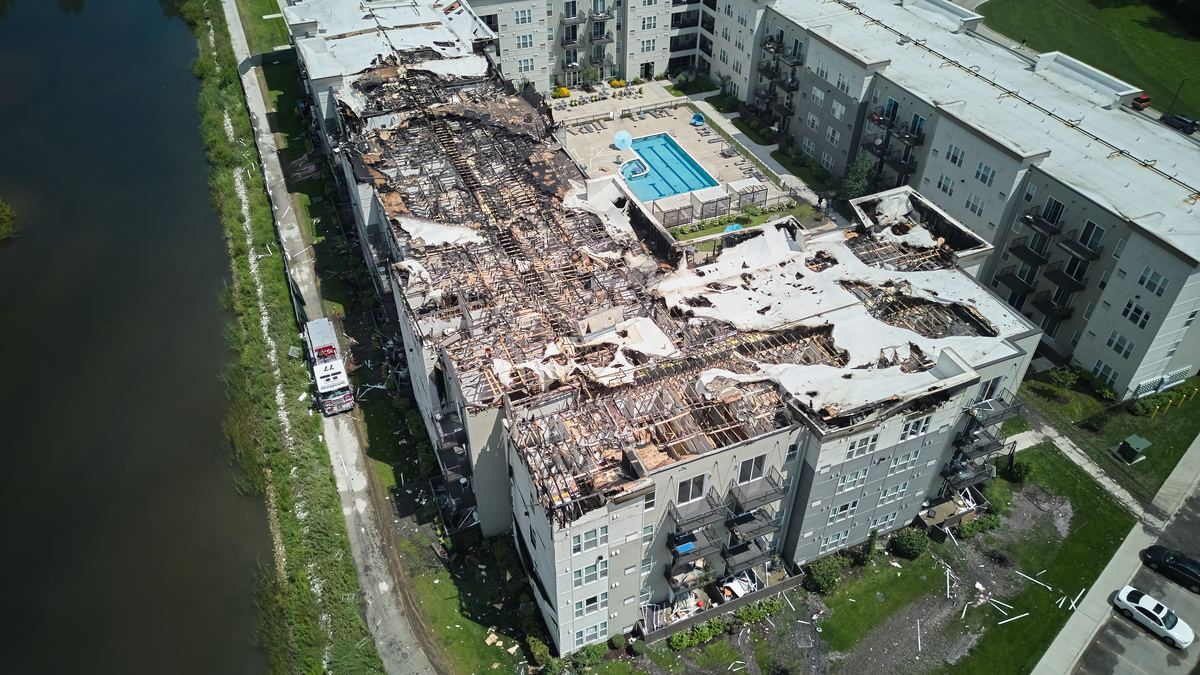 Aerial view of a multi-unit condo or HOA association building with collapsed roof after a hurricane