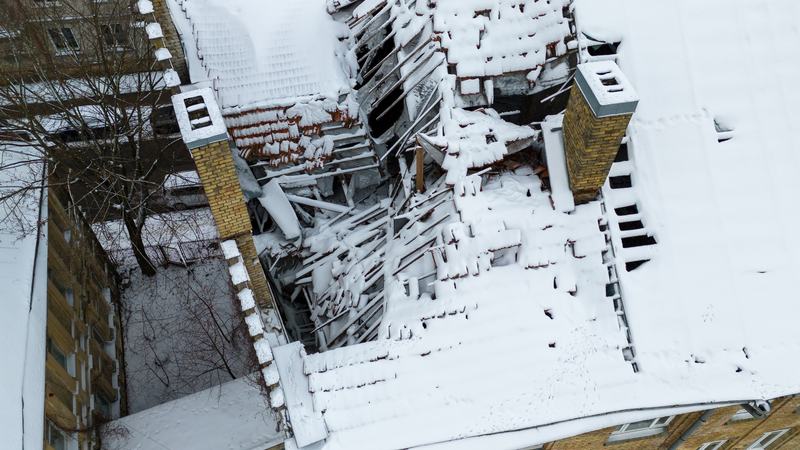 Collapsed roof structure under heavy snow at a condo or HOA association building