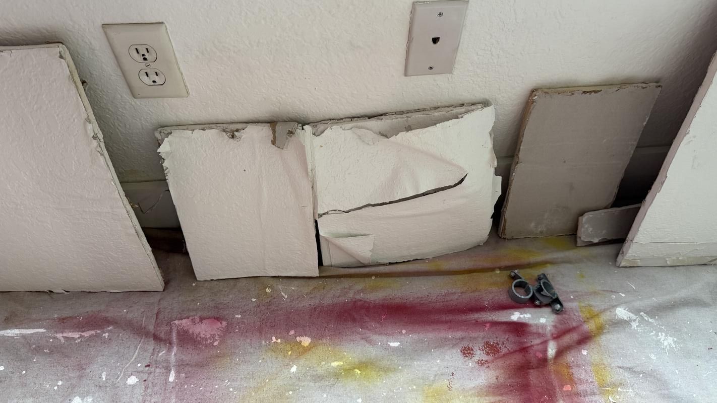 Patched drywall sections from a frozen-pipe repair inside a condo unit