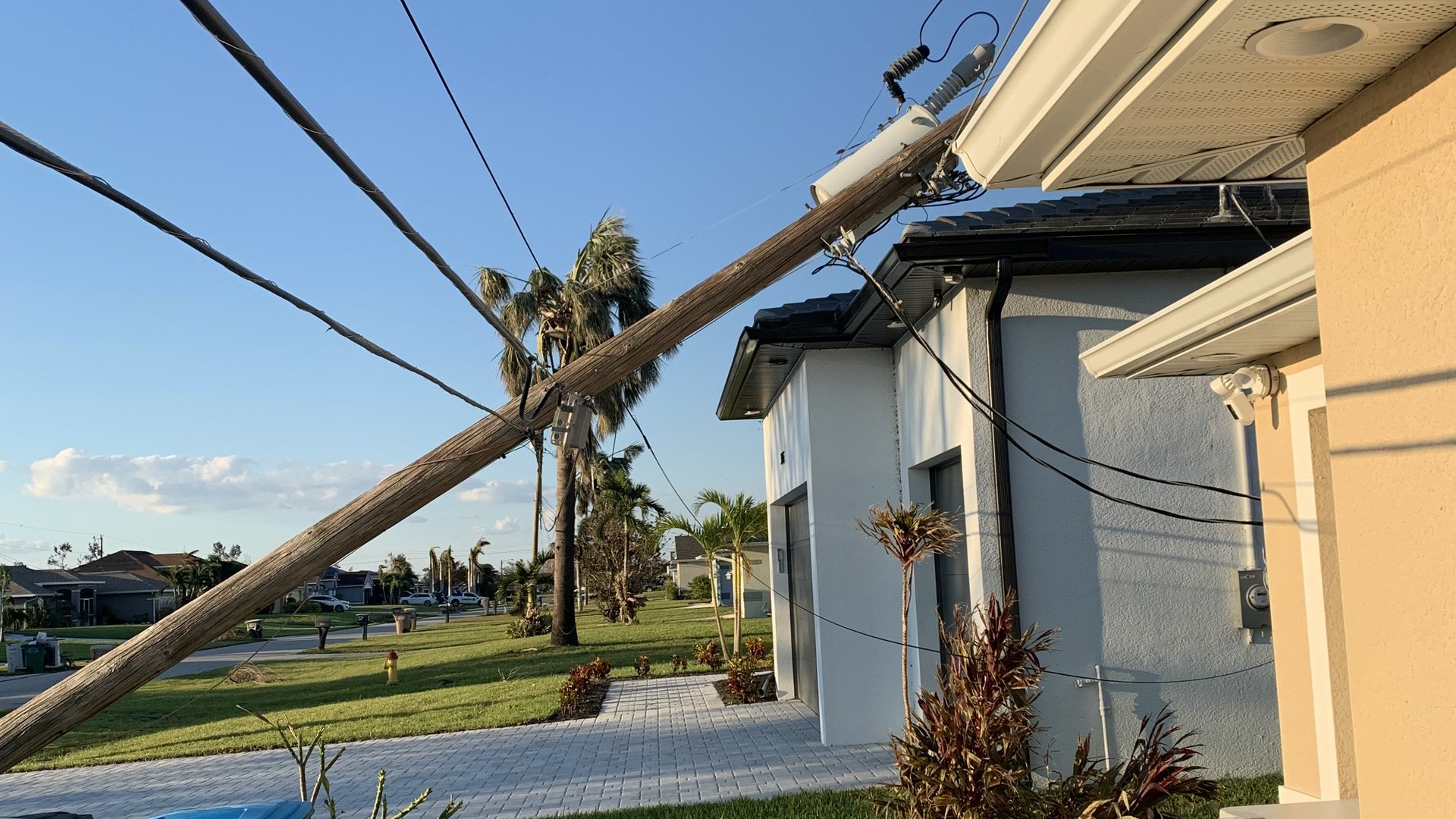 A power pole and lines down across a Florida yard after a hurricane