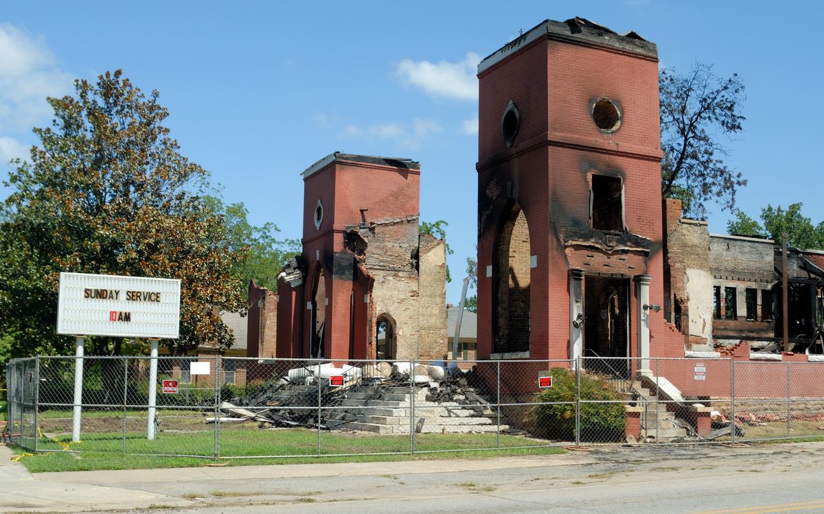 Fire-damaged church exterior with collapsed roof