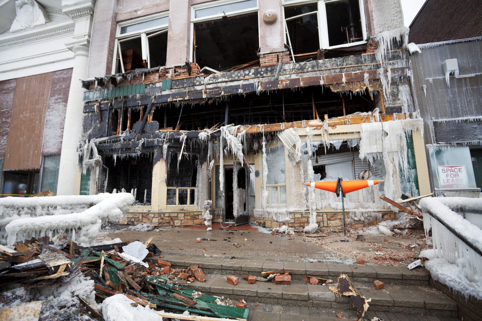 Fire-damaged restaurant storefront, closed, with charred facade