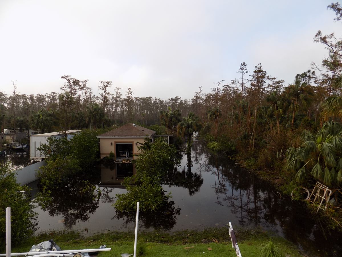 Standing floodwater around a home after heavy rain in Naples, FL