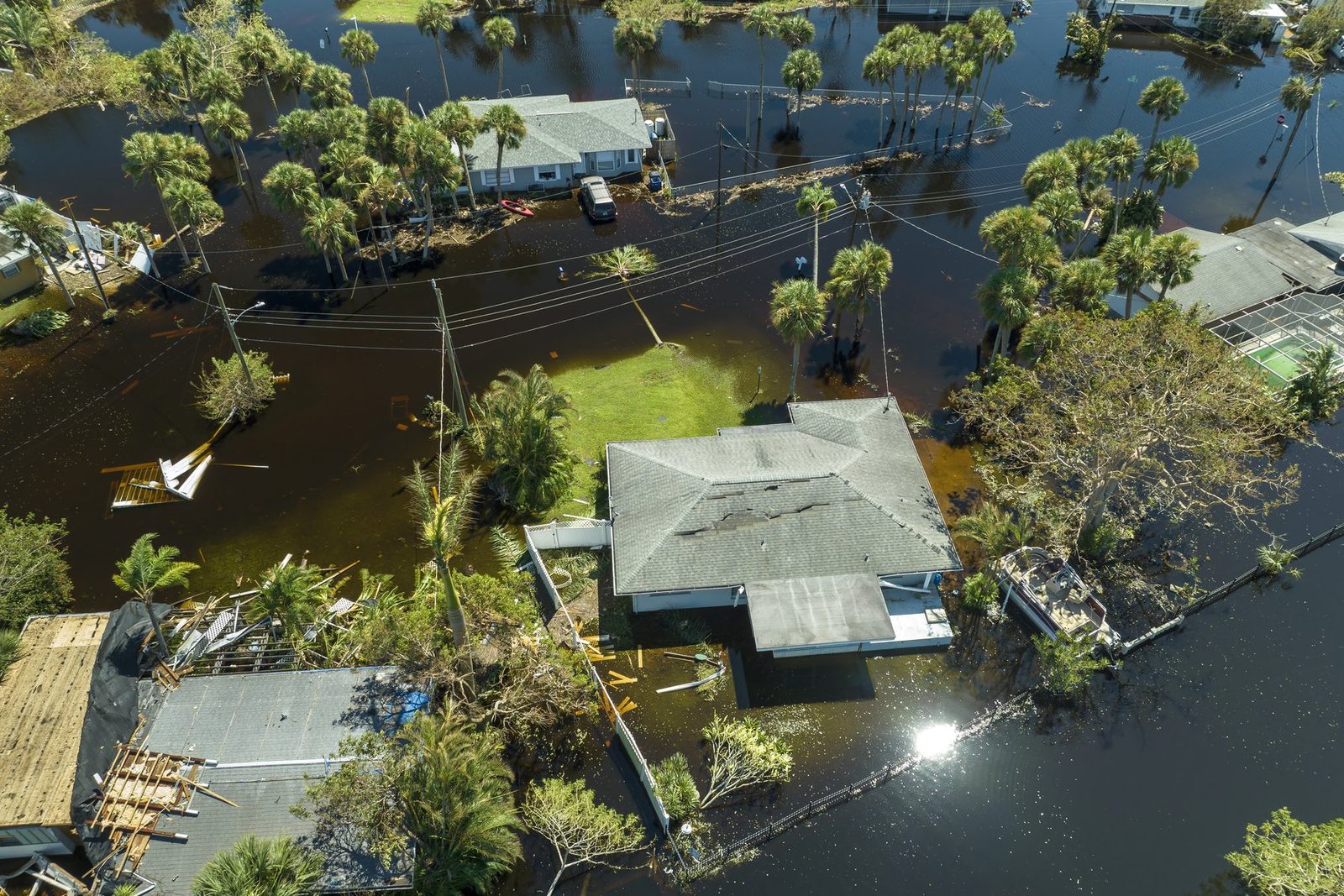 Aerial view of floodwater surrounding homes and palm trees after a Florida hurricane