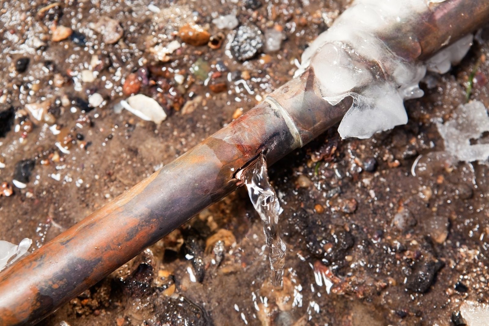 A frozen copper pipe split open and leaking