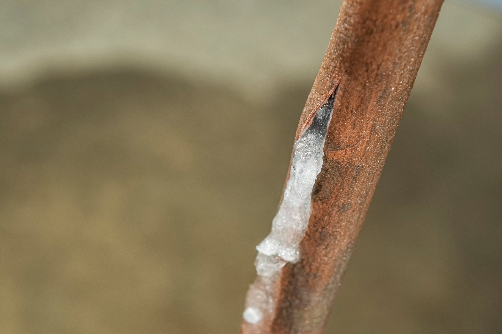 Ice forming on a split copper water pipe