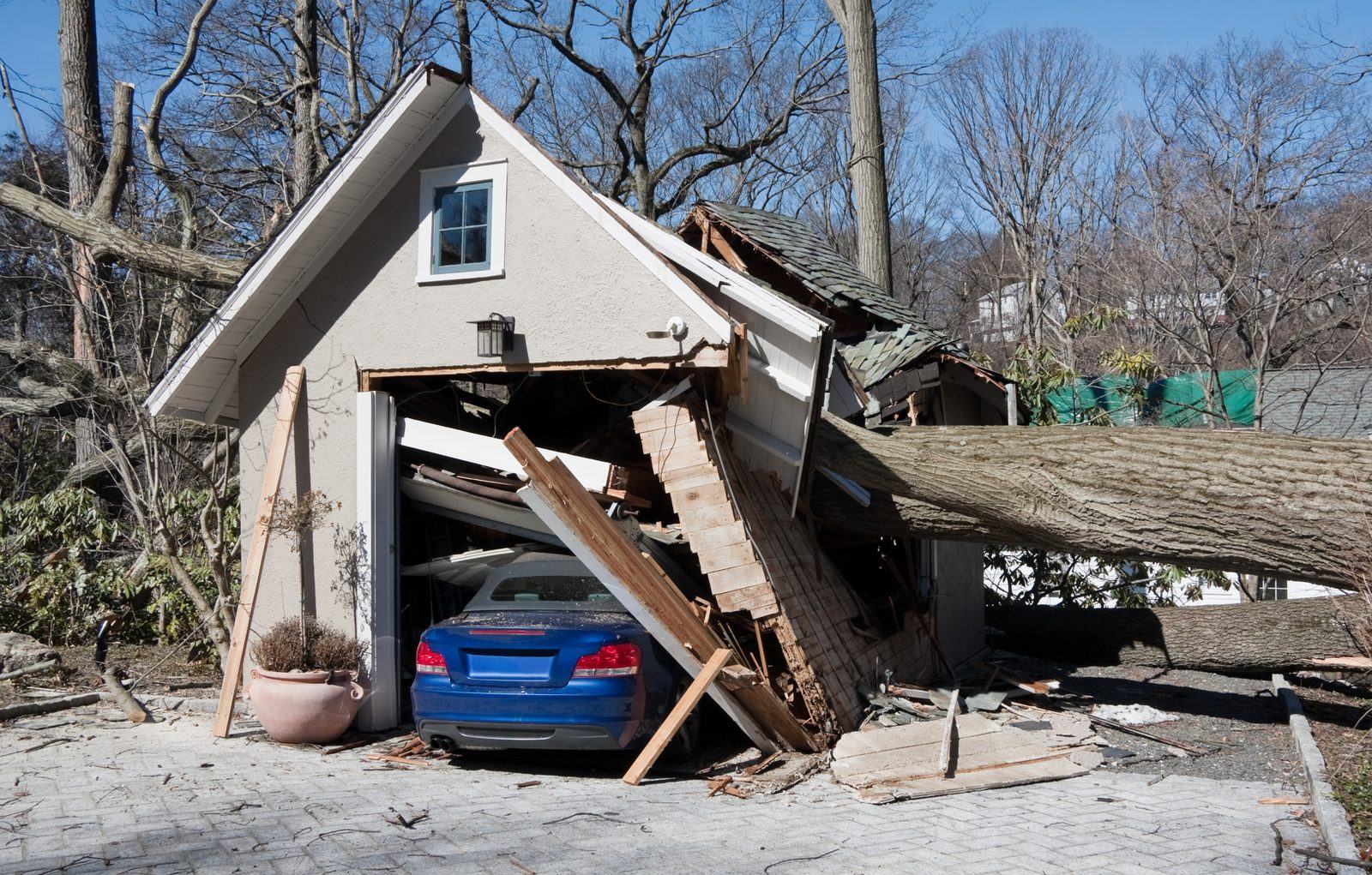 Detached garage roof collapsed onto a car under winter snow load