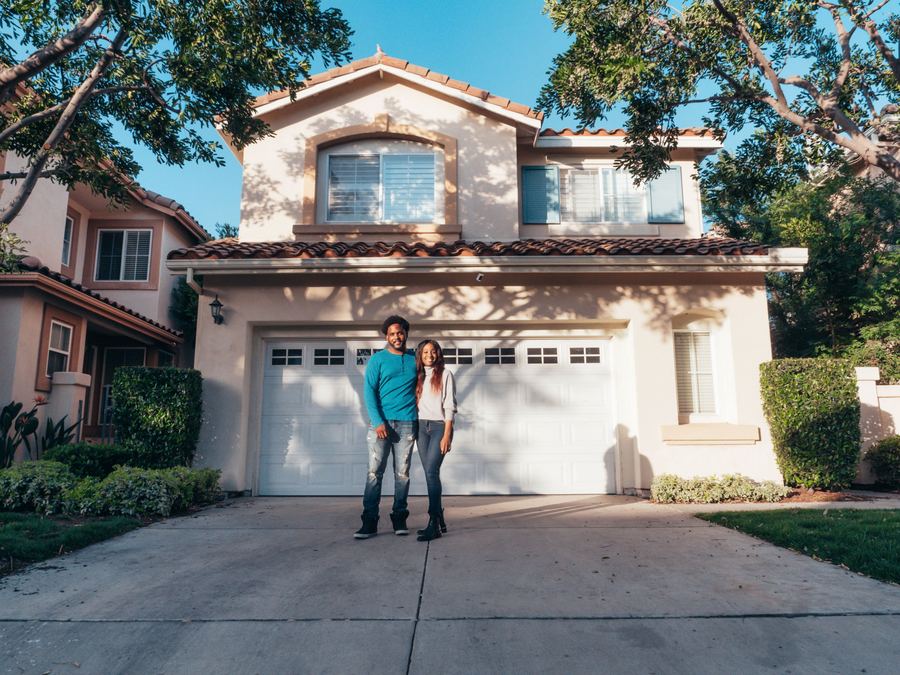 A couple standing in the driveway outside their home
