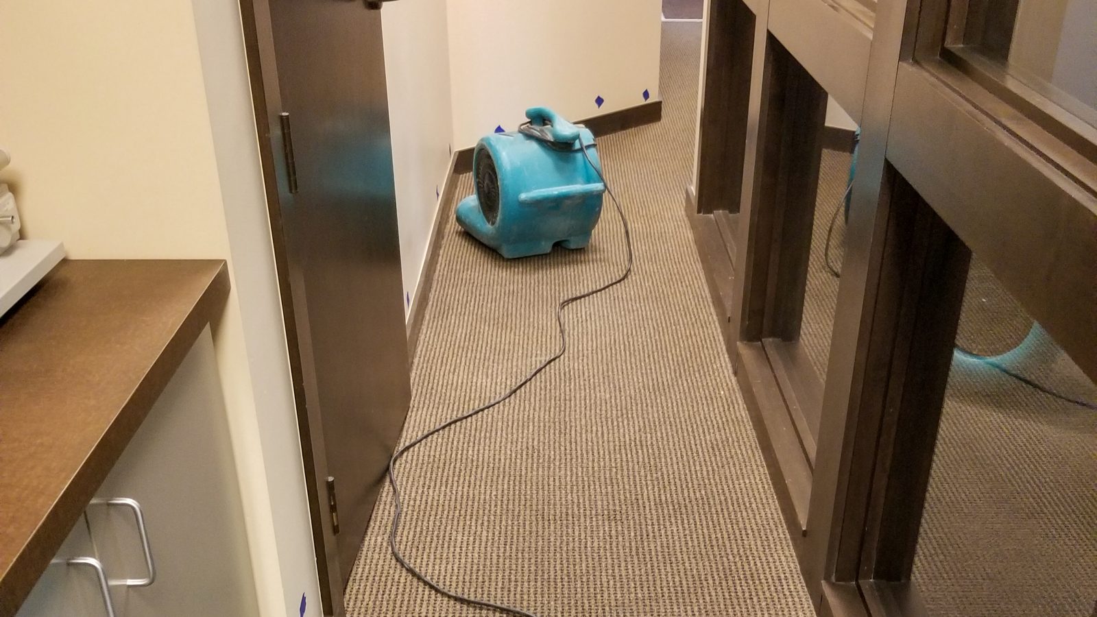 Hotel corridor with drying fans running after water damage