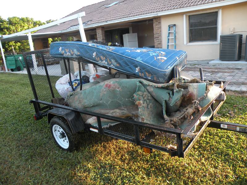 Hurricane-damaged furniture and contents loaded for removal at a home in Homestead, FL
