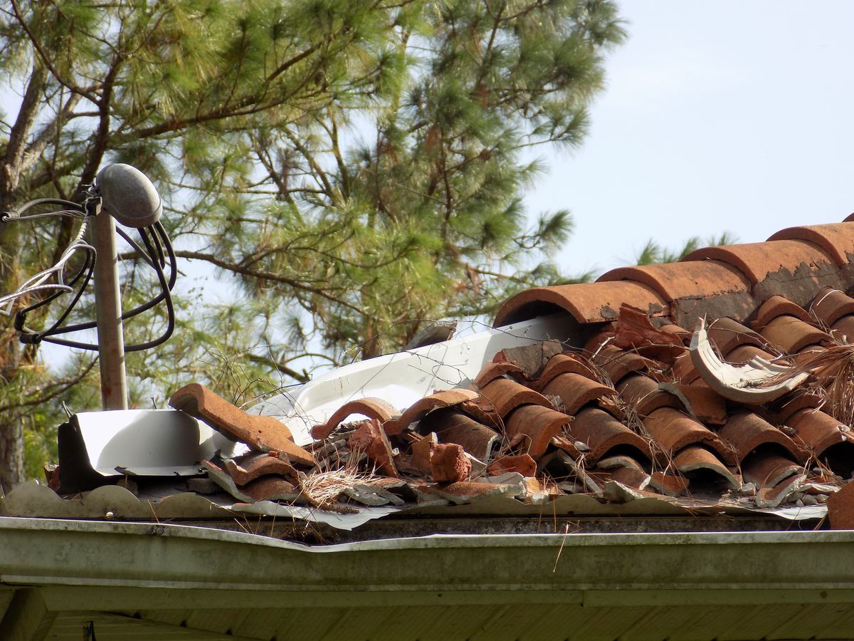 Wind-damaged roof tiles on a Florida home after a hurricane, the kind of loss a hurricane deductible applies to