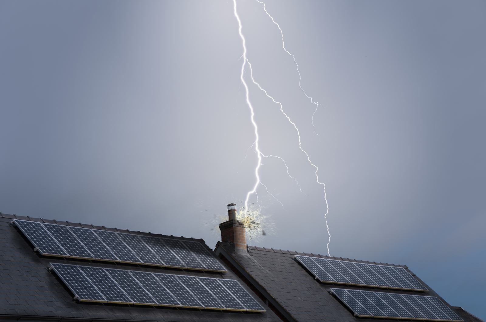 Lightning bolt striking the chimney of a house with rooftop solar panels