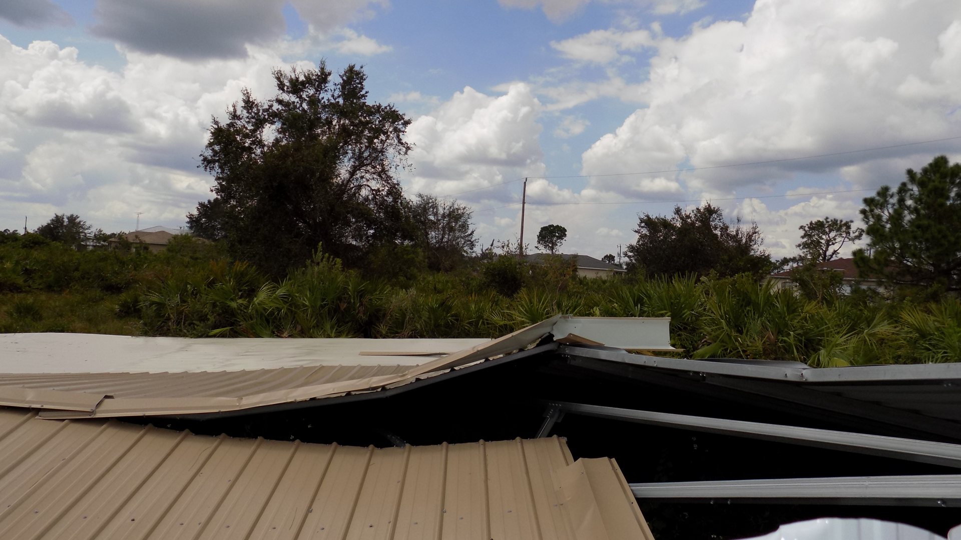 Metal roof panels peeled back by hurricane winds in Lehigh Acres, Florida