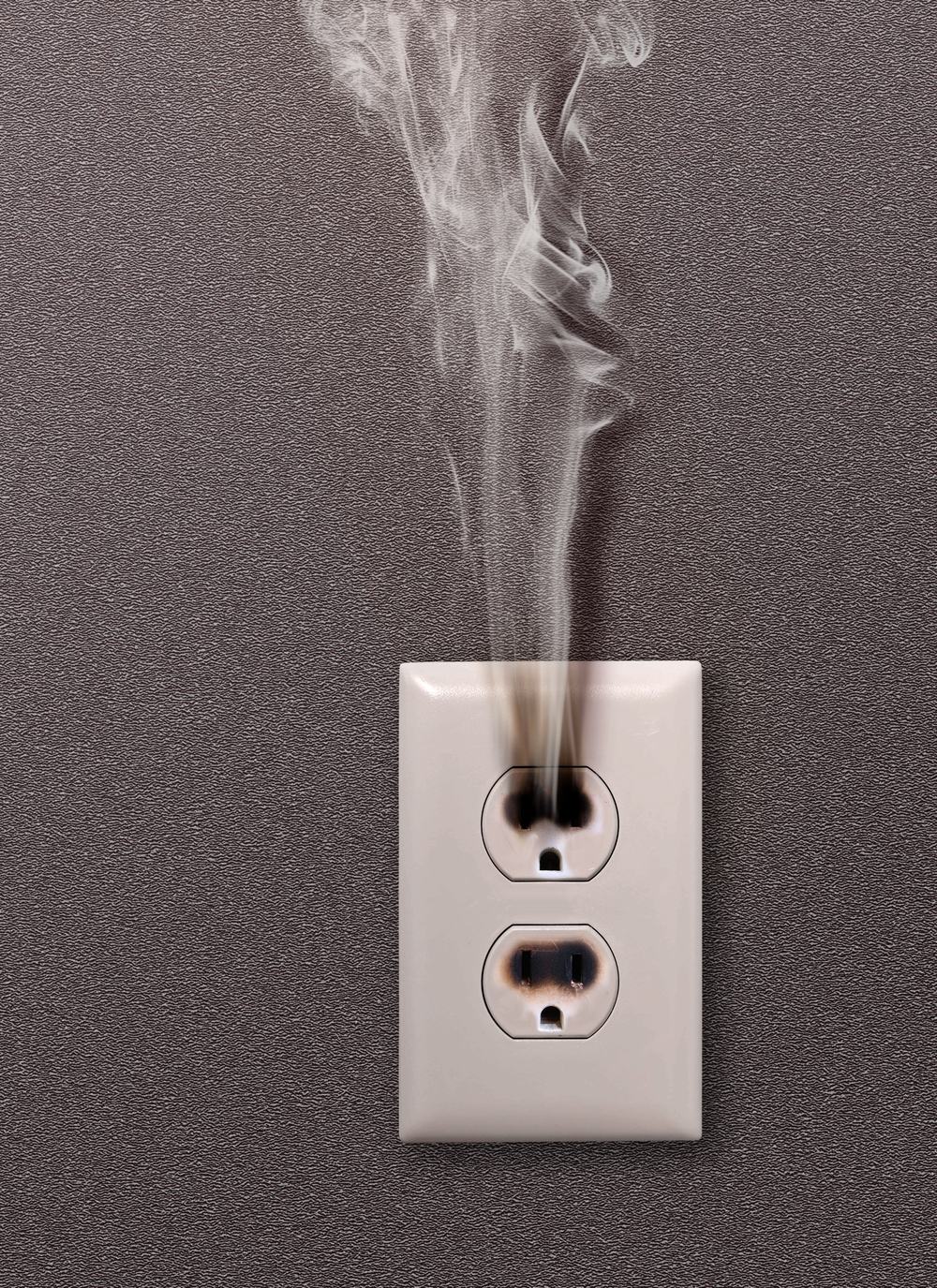 Smoke rising from a wall outlet after a power surge