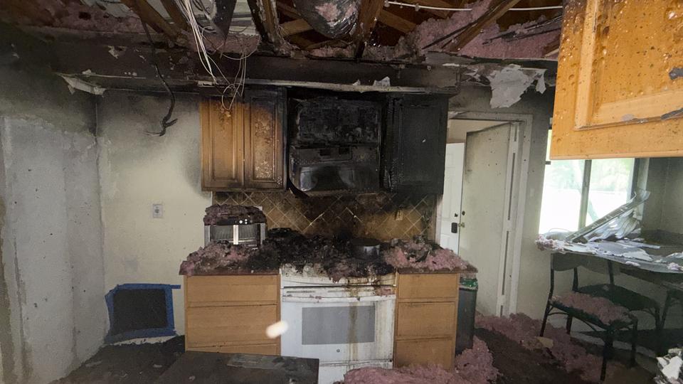 Burned kitchen cabinets and stove after a fire at a home in Aventura, FL