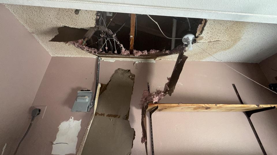 Collapsed ceiling exposing insulation and framing from storm damage at a home in Boca Raton, FL