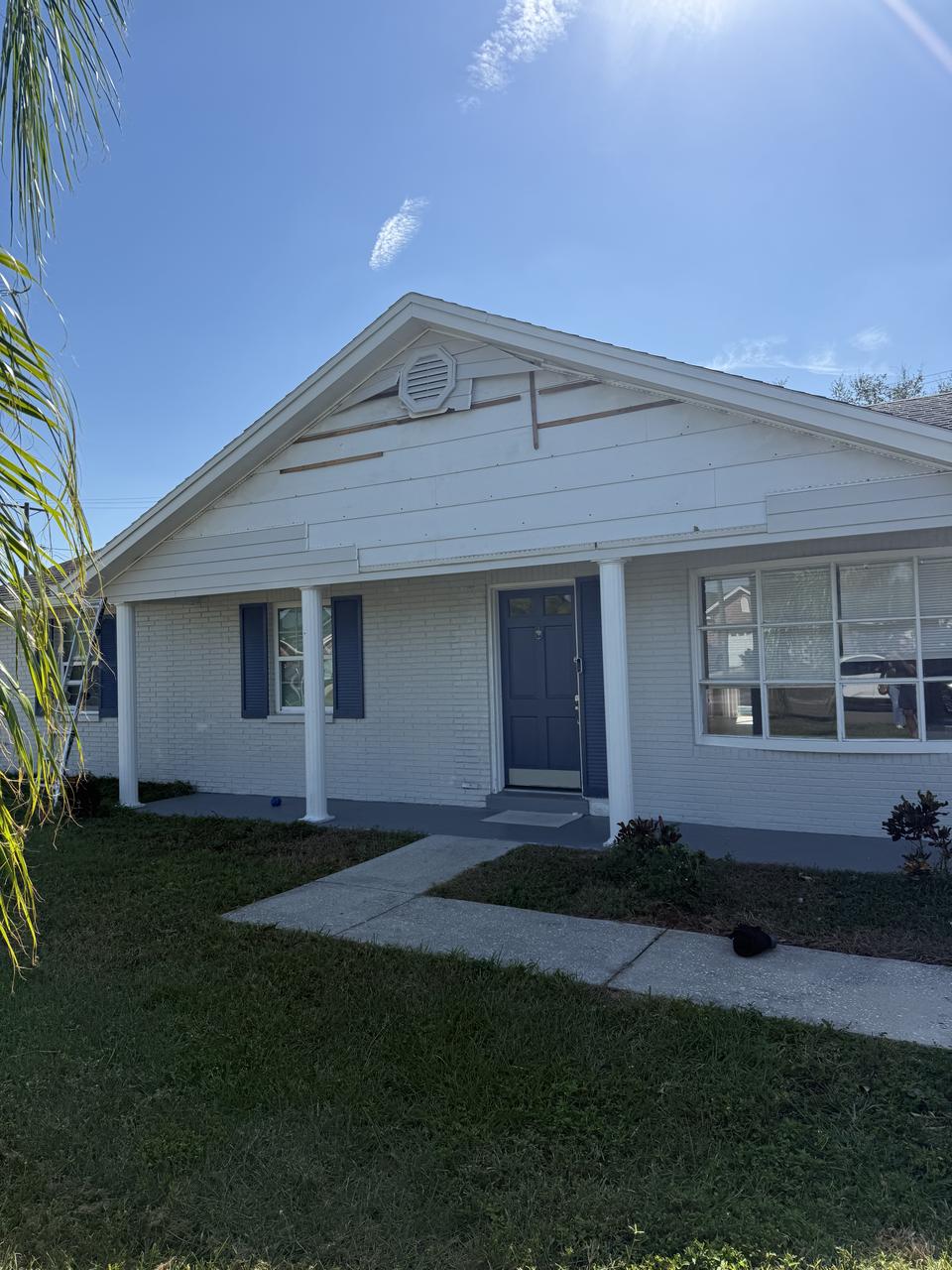 Exterior of a storm-damaged home with lifted gable siding in Clearwater, FL