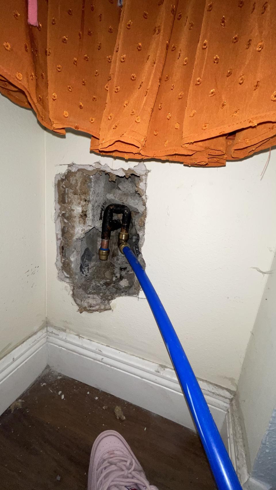 Wall opened to a damaged pipe behind a shutoff valve at a home in Coral Springs, FL
