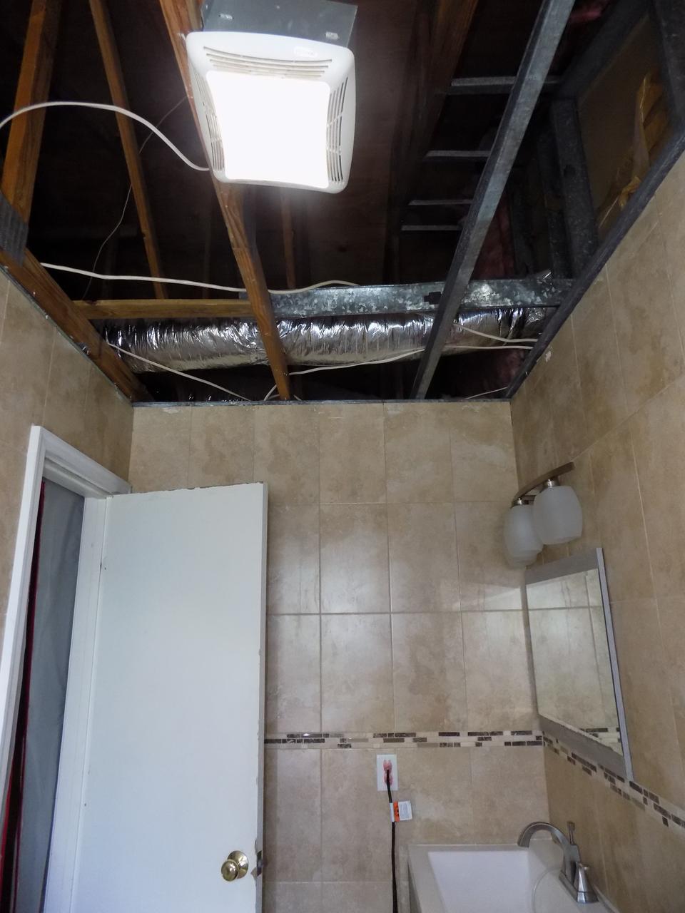Gutted bathroom ceiling with exposed ductwork and framing at a home in Delray Beach, FL