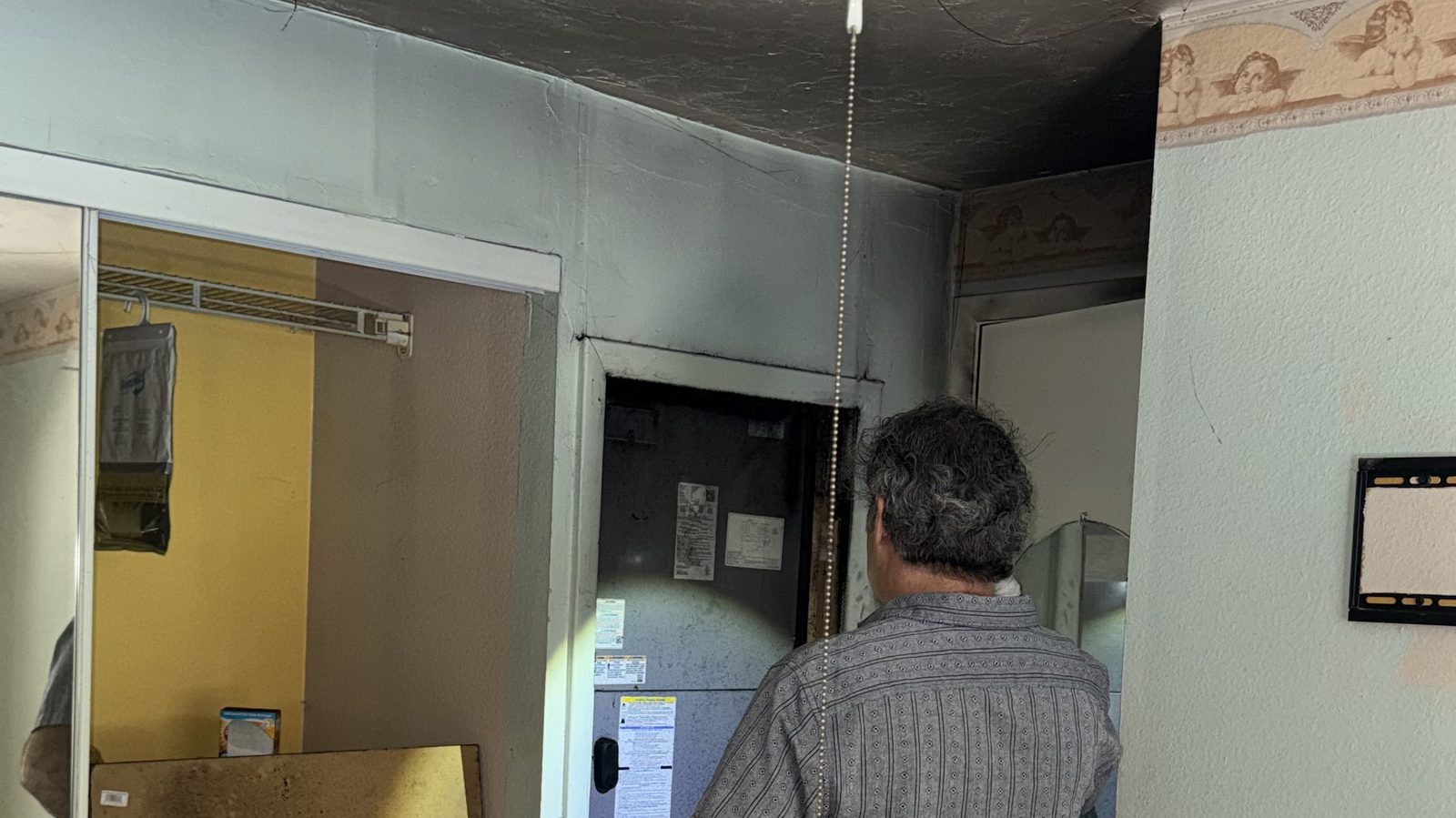 Ajustador público con una carpeta inspeccionando un pasillo interior