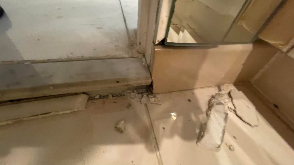 Water-damaged tile flooring and baseboard in a Miami Springs home after a plumbing leak