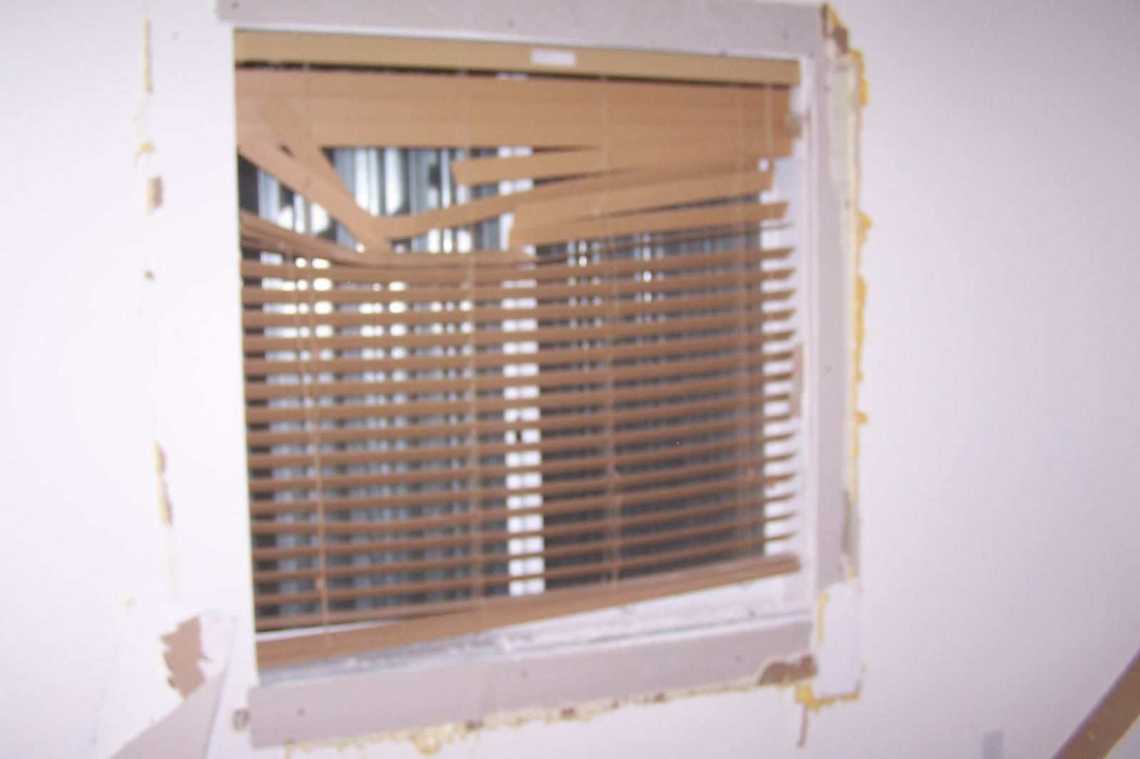 Damaged window and blinds inside a rental property unit