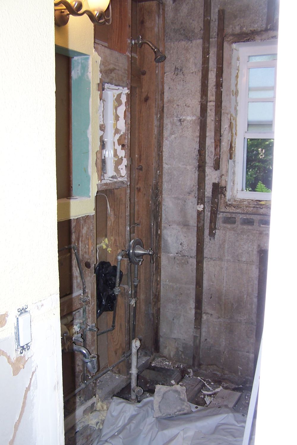 Gutted bathroom with exposed wall studs during repair at a vacant rental unit