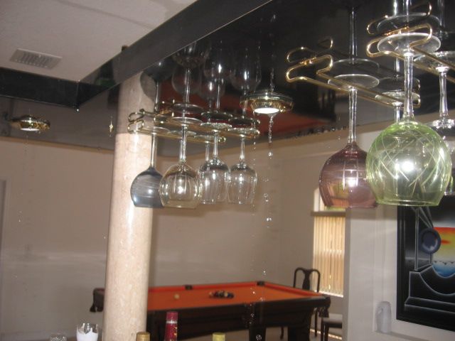 Water dripping from the ceiling onto a glass rack and bar area from the unit upstairs