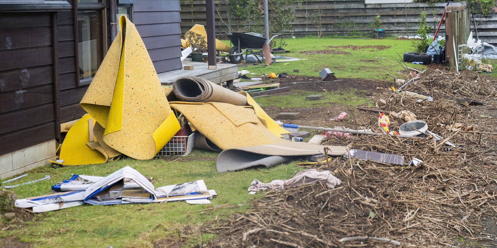 Storm debris scattered across a rural property yard