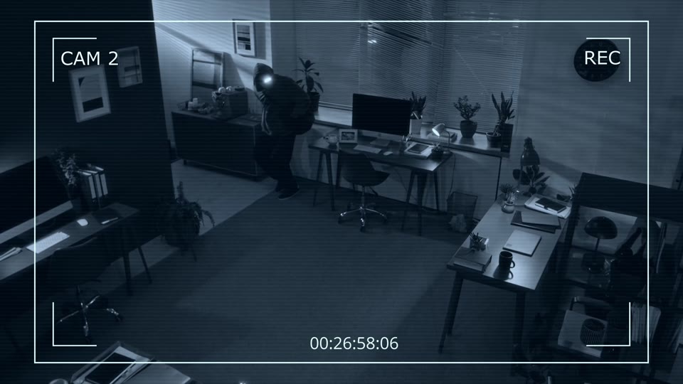 Security-camera view of a broken-into office at night