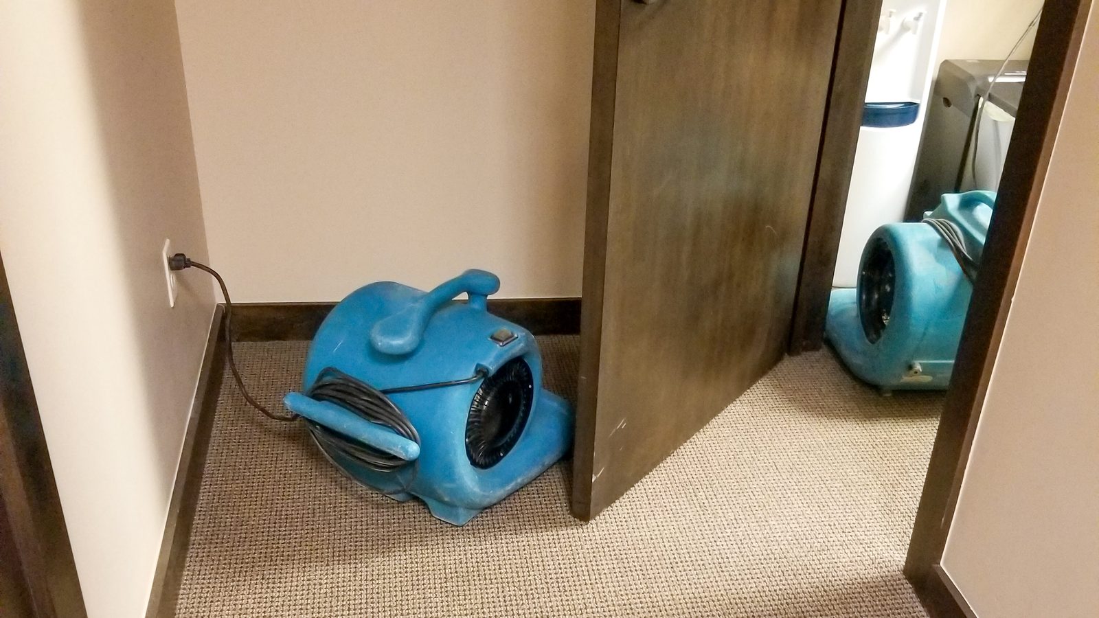 Air mover drying a furnished vacation rental room after a water leak