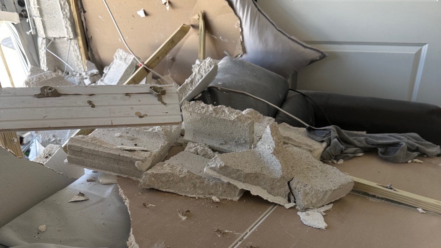 Bedroom ceiling collapsed with debris on the bed after a vehicle struck the house