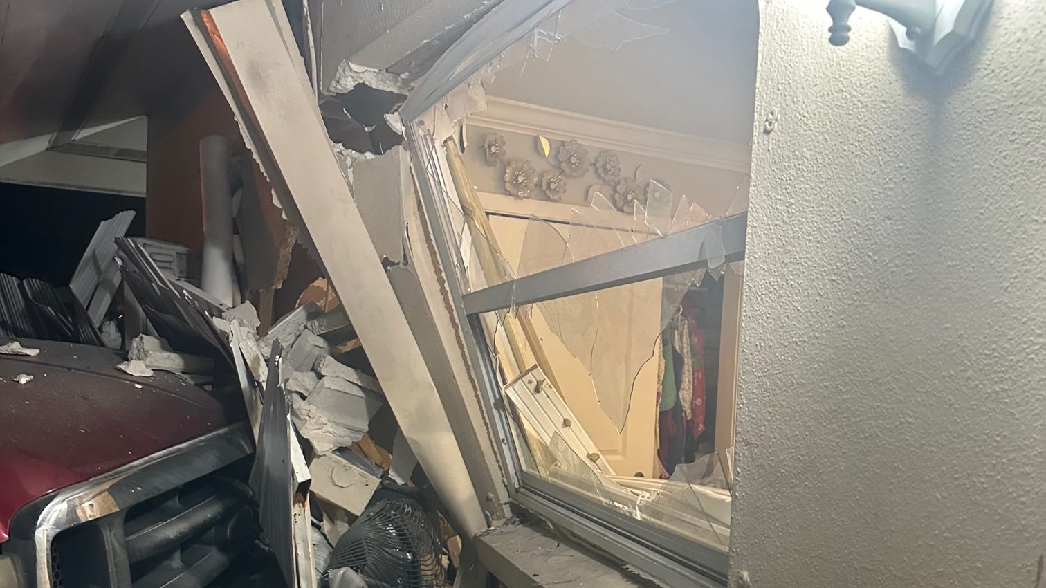 Ceiling and wall debris inside a garage after a vehicle crashed into the home