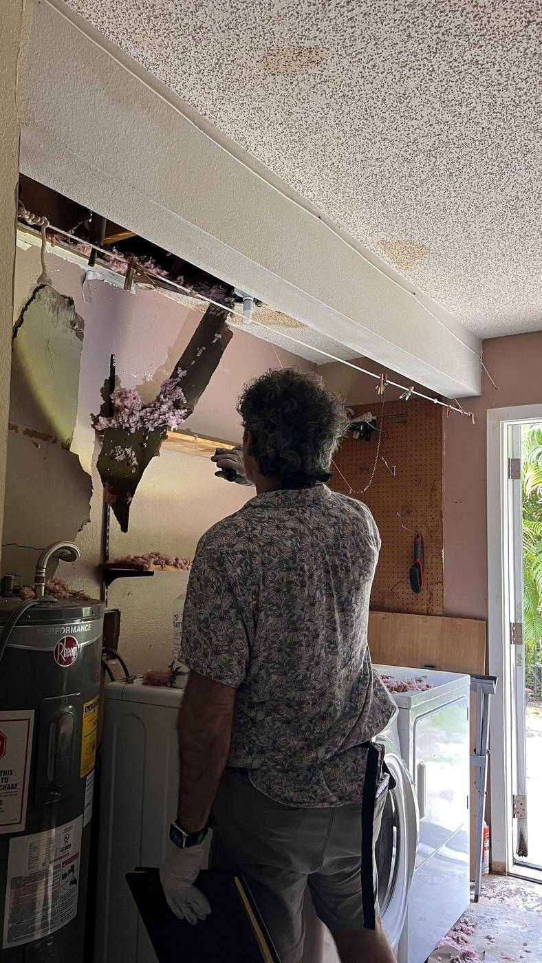 Public adjuster inspecting an opened ceiling after a leak — the kind of claim Homeland handles for Bradenton, FL property owners