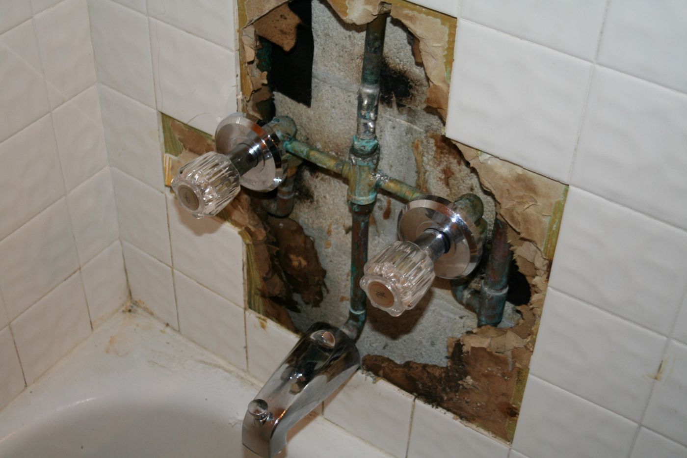 Exposed plumbing and water damage behind a bathroom wall — the kind of claim Homeland documents for Indian River County, FL property owners