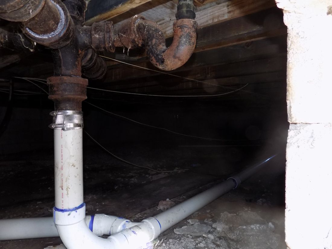 Corroded cast-iron drain lines in a crawl space — the kind of claim Homeland handles for Toms River, NJ property owners