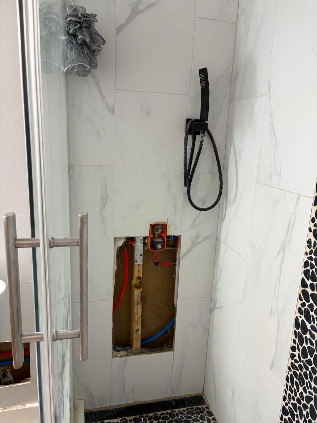 Shower wall opened to reach a leaking valve and supply lines — the kind of claim Homeland handles for Hoboken, NJ property owners